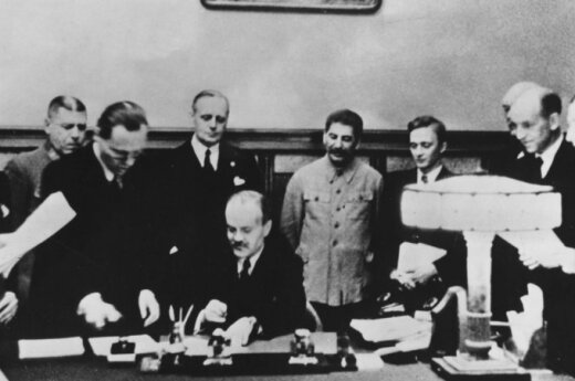 Molotovo-Ribbentropo pakto pasirašymas 1939 m. rugpjūčio 23 d. Prie stalo sėdi Viačeslavas Molotovas, už jo stovi Joachimas von Ribbentropas ir Josifas Stalinas.